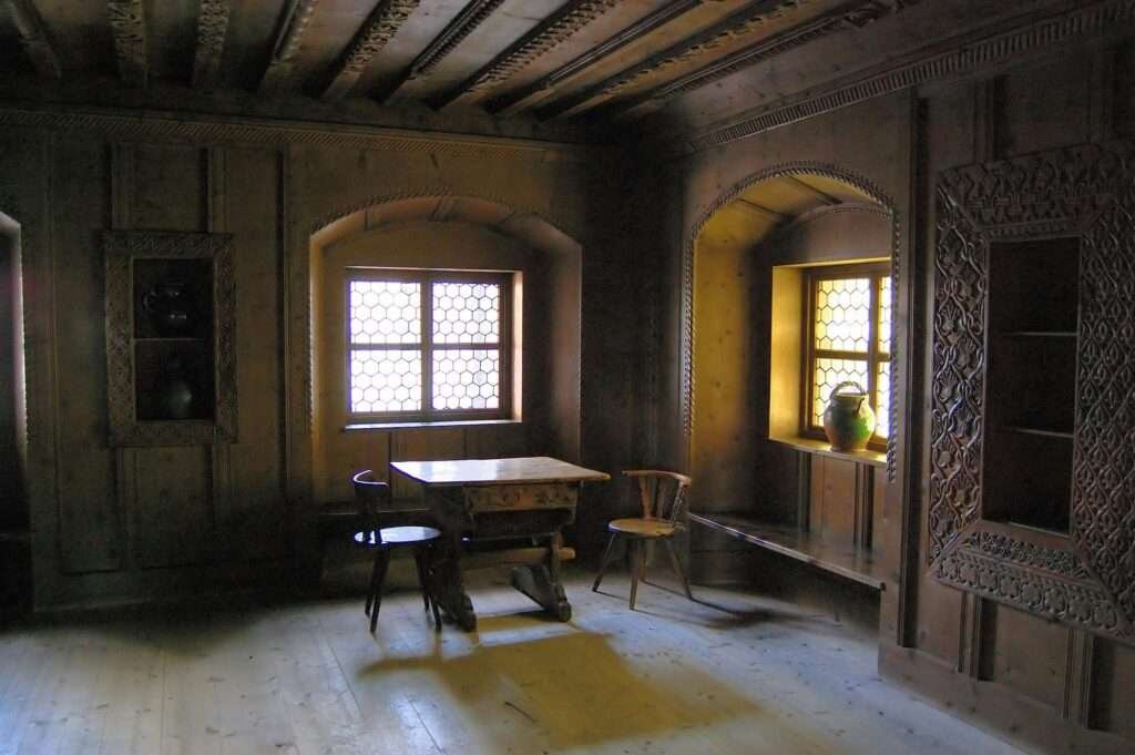 Charming rustic room with wooden interior and ornate carvings, featuring vintage furniture.